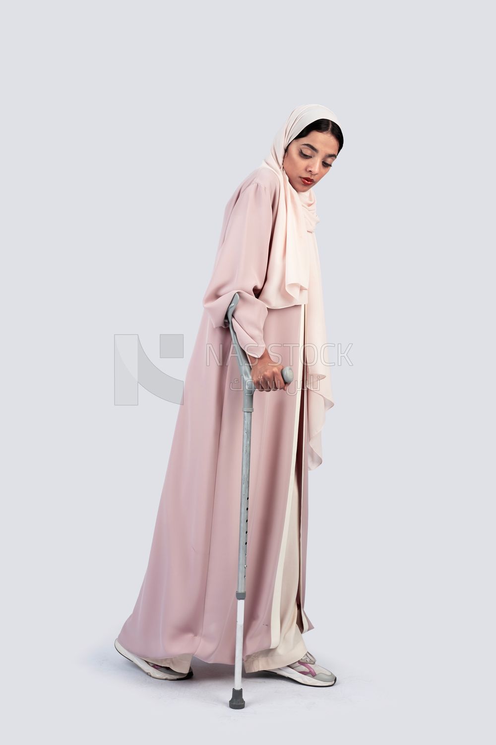 Saudi Gulf woman leaning on crutches