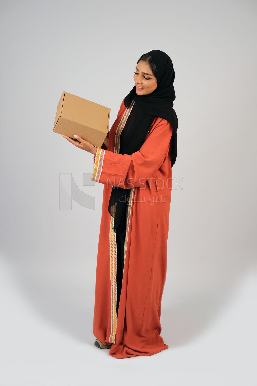 Saudi Gulf girl holding a cardboard delivery box