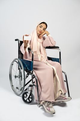 Girl sitting in wheelchair holding white card