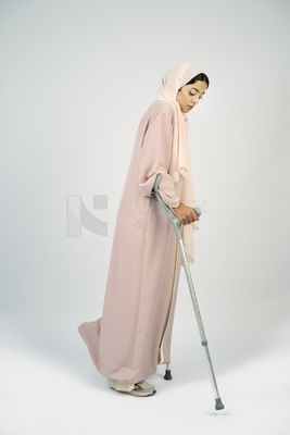 Saudi Gulf woman leaning on crutches