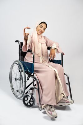 Girl sitting in wheelchair holding white card