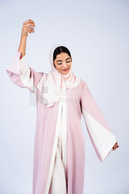 Gulf woman wearing abaya and hijab spraying perfume