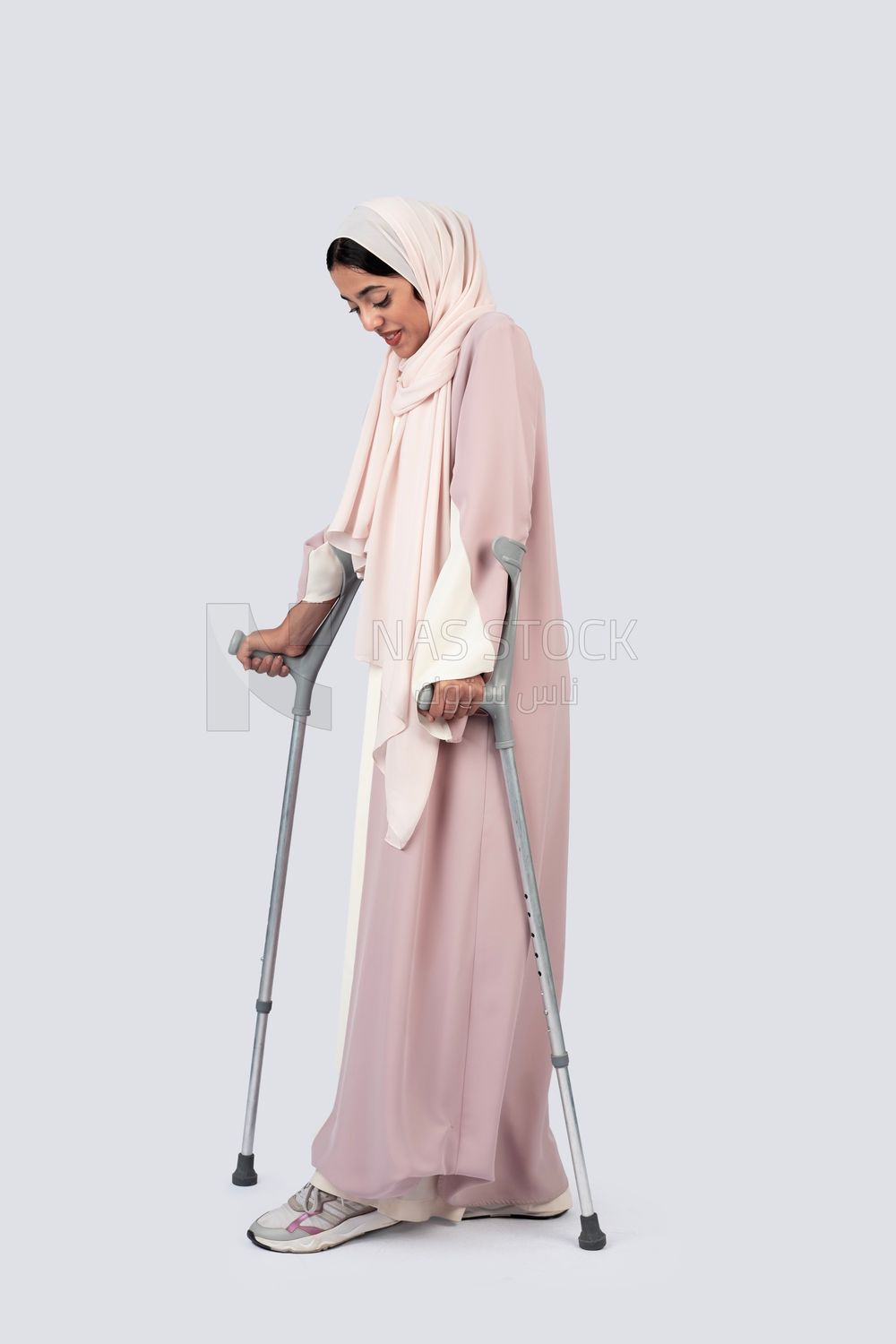 Gulf woman leaning on crutches