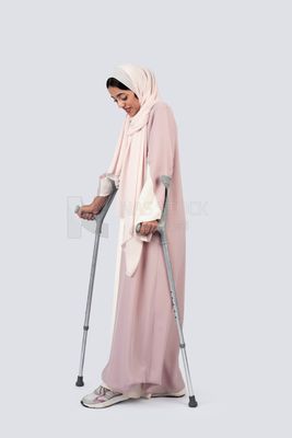 Gulf woman leaning on crutches