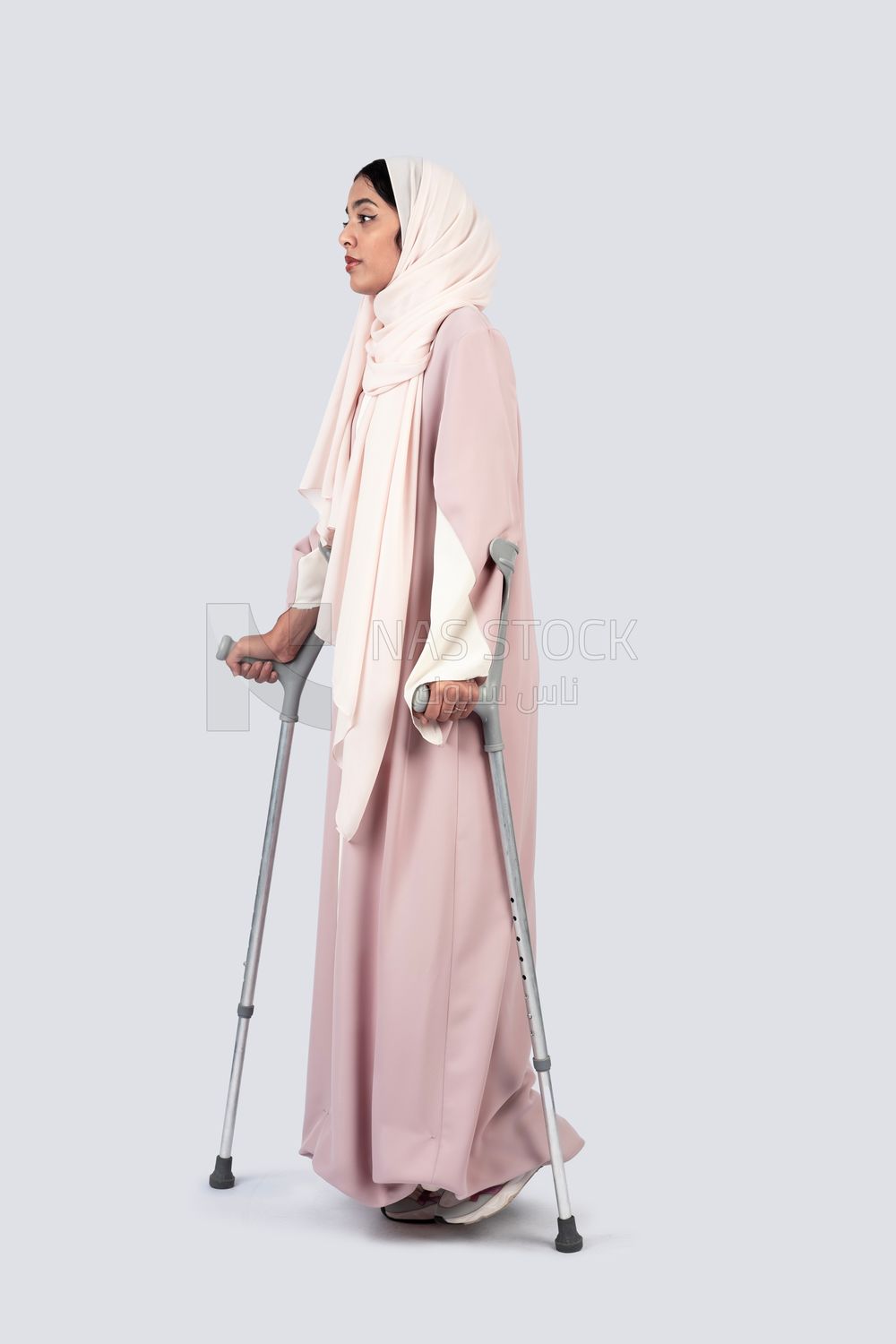 Gulf woman leaning on crutches