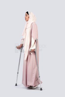 Gulf woman leaning on crutches