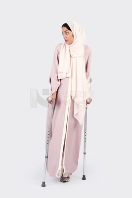 Gulf woman leaning on crutches