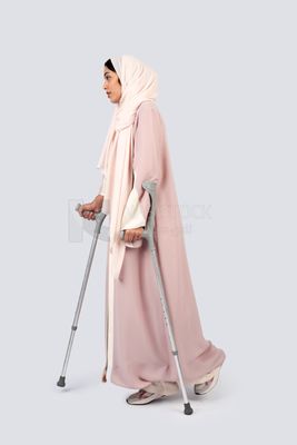 Gulf woman leaning on crutches