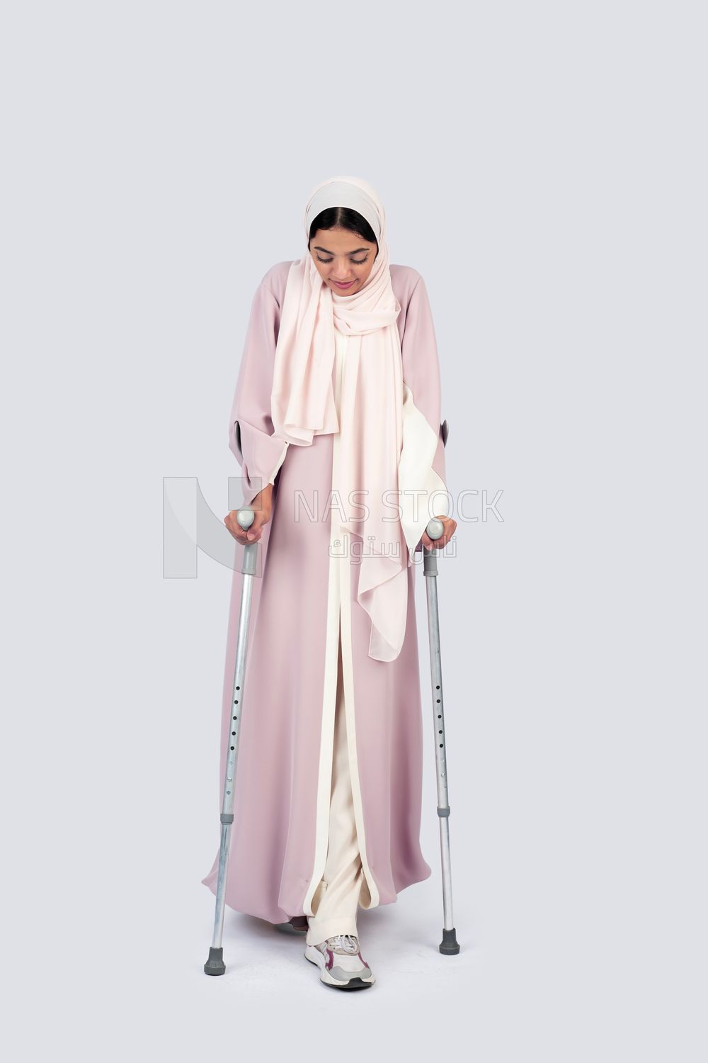 Gulf woman leaning on crutches