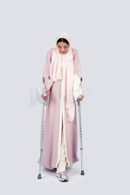 Gulf woman leaning on crutches