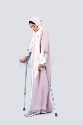 Gulf woman leaning on crutches