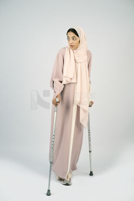 Saudi Gulf woman leaning on crutches