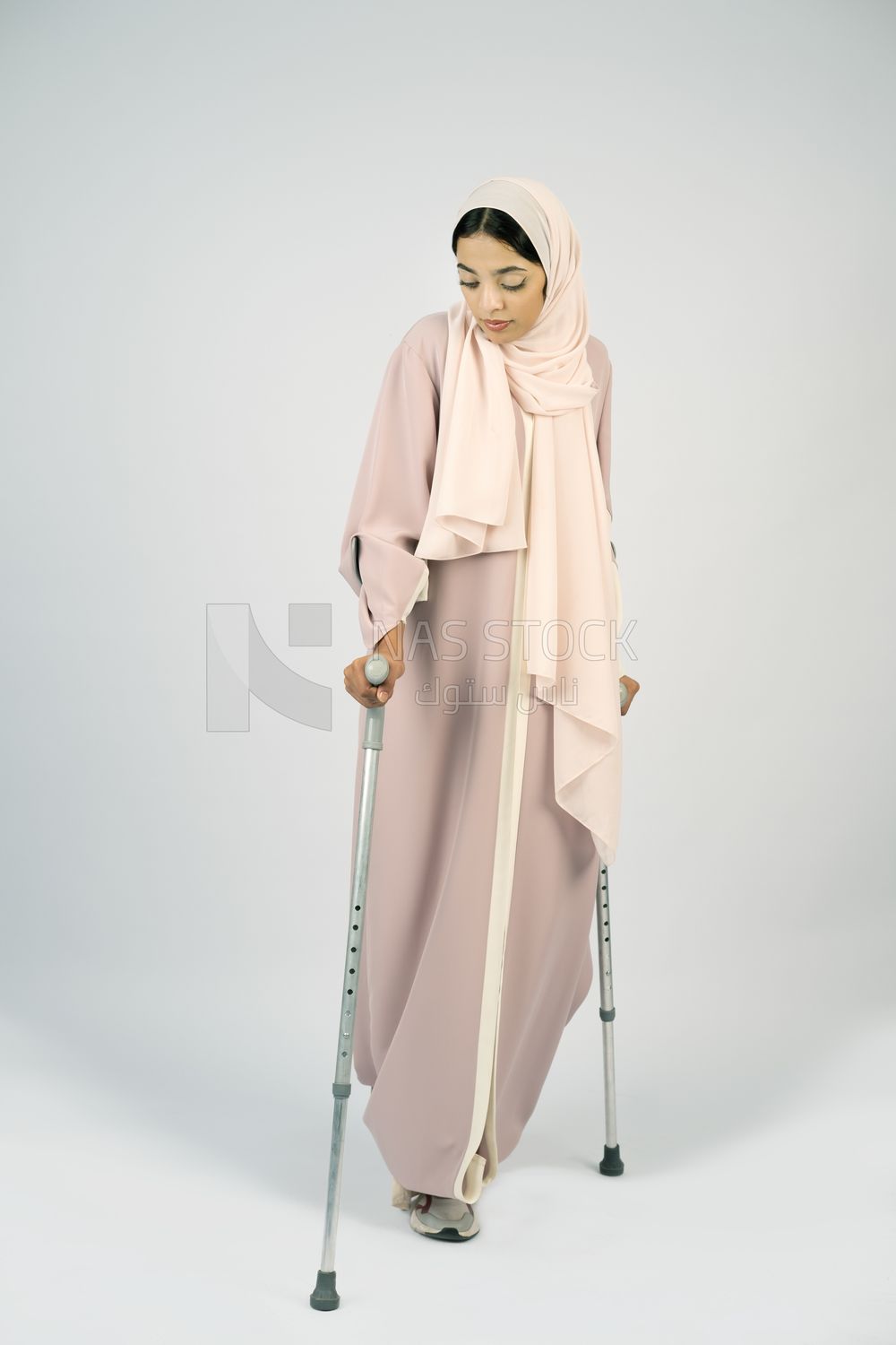 Saudi Gulf woman leaning on crutches