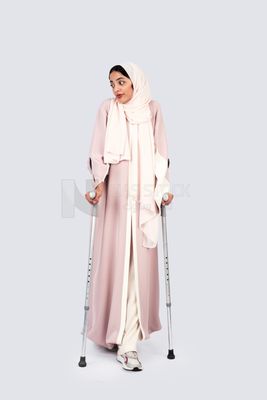 Gulf woman leaning on crutches