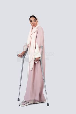 Gulf woman leaning on crutches