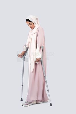 Gulf woman leaning on crutches