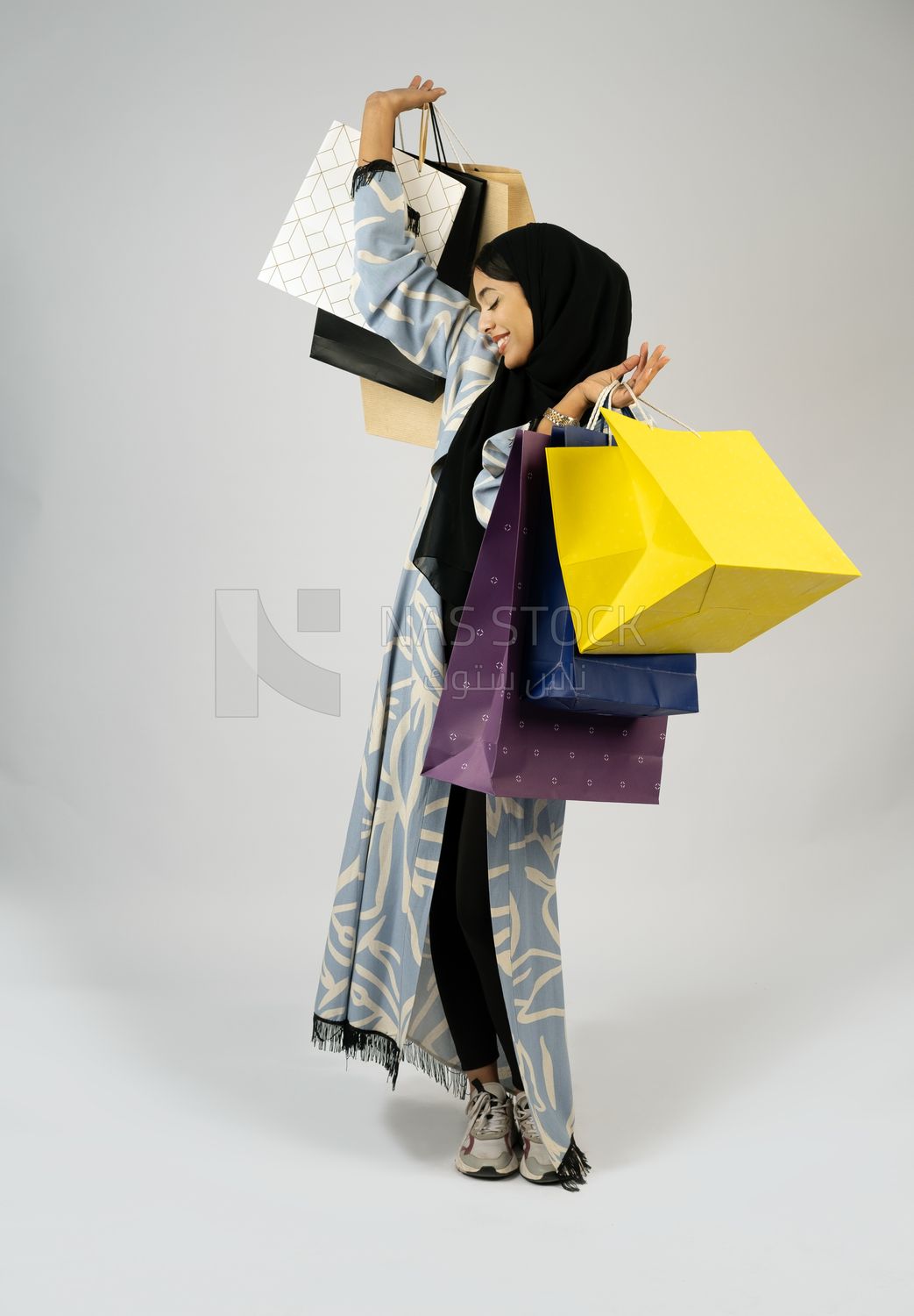 Gulf girl carrying colorful shopping bags