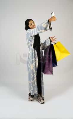 Gulf girl holding colorful shopping bags taking selfie
