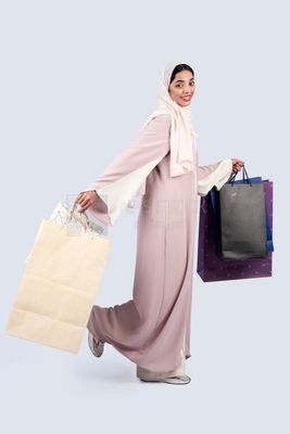 Gulf woman carrying colorful shopping bags
