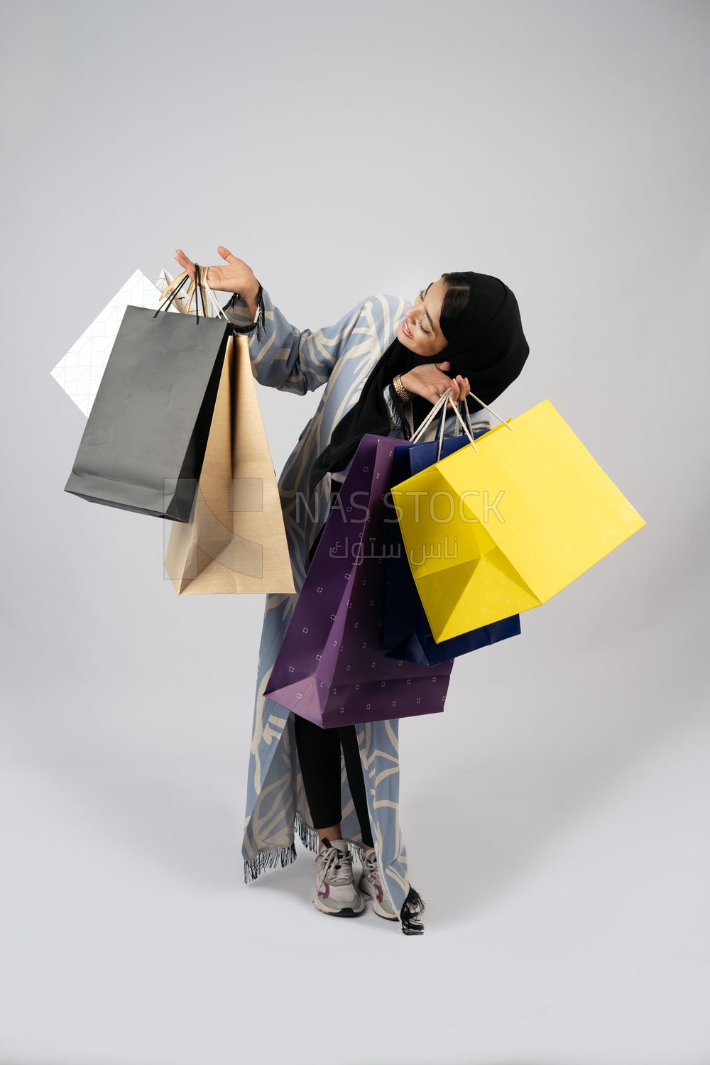 Gulf girl carrying colorful shopping bags