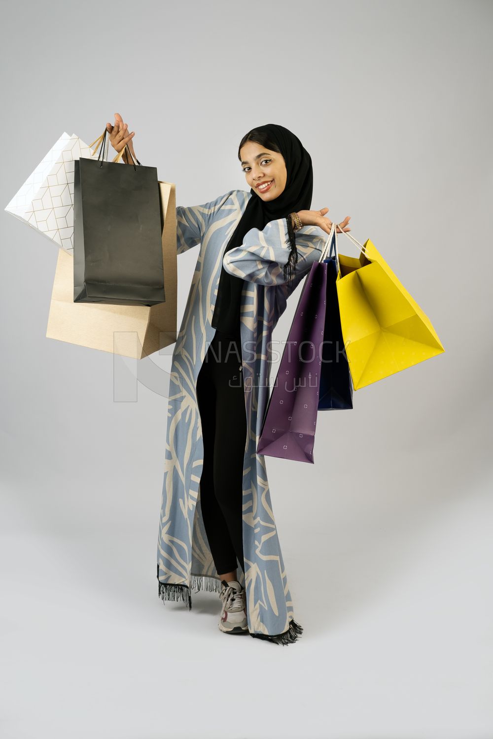 Gulf girl carrying colorful shopping bags