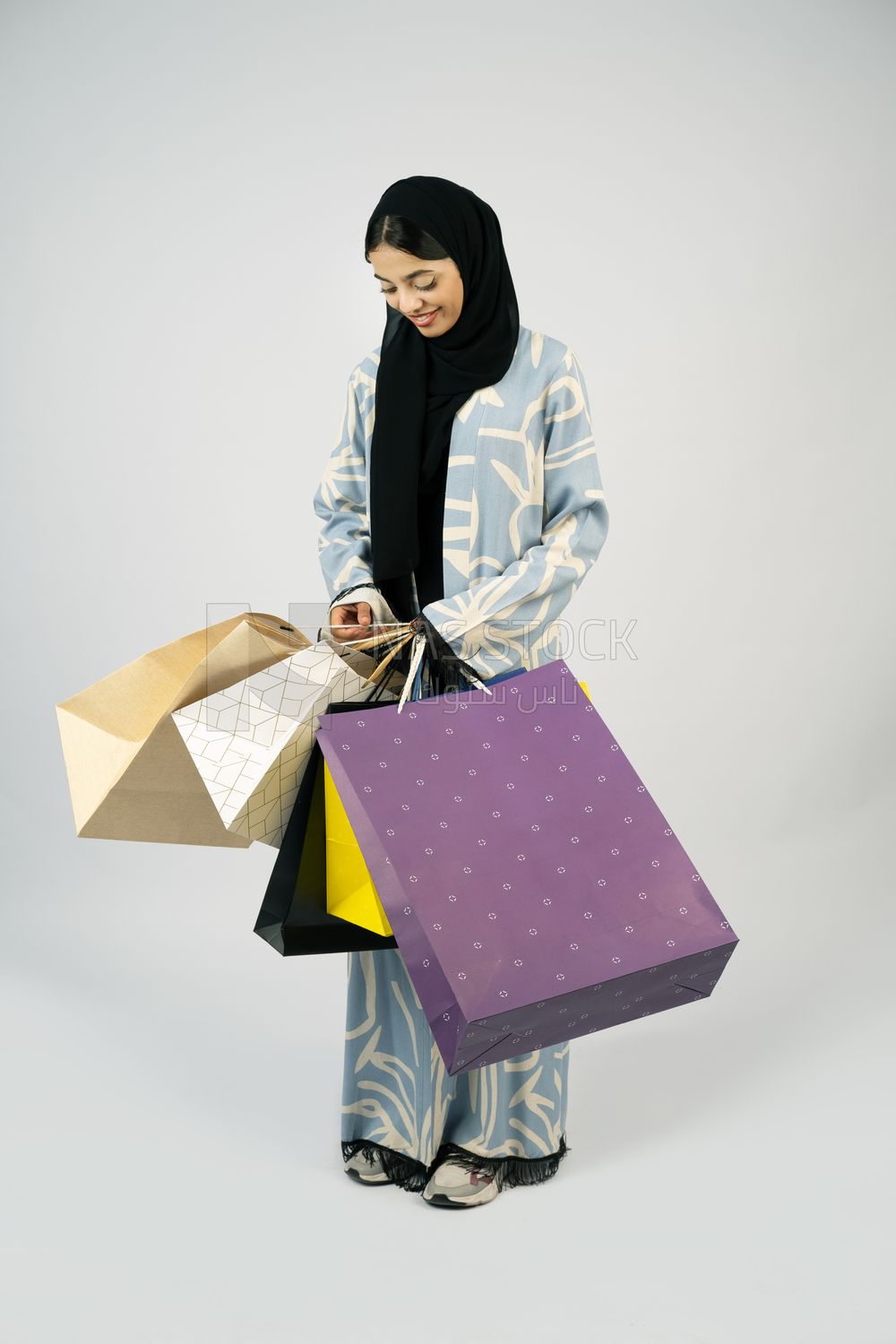 Gulf girl carrying colorful shopping bags