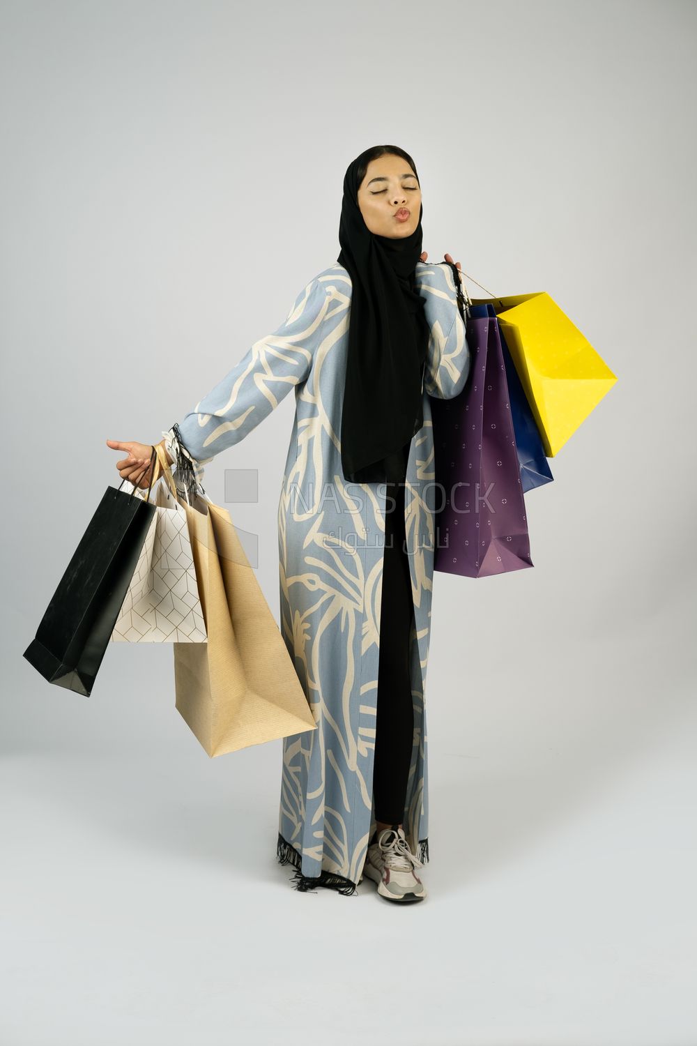Gulf girl carrying colorful shopping bags