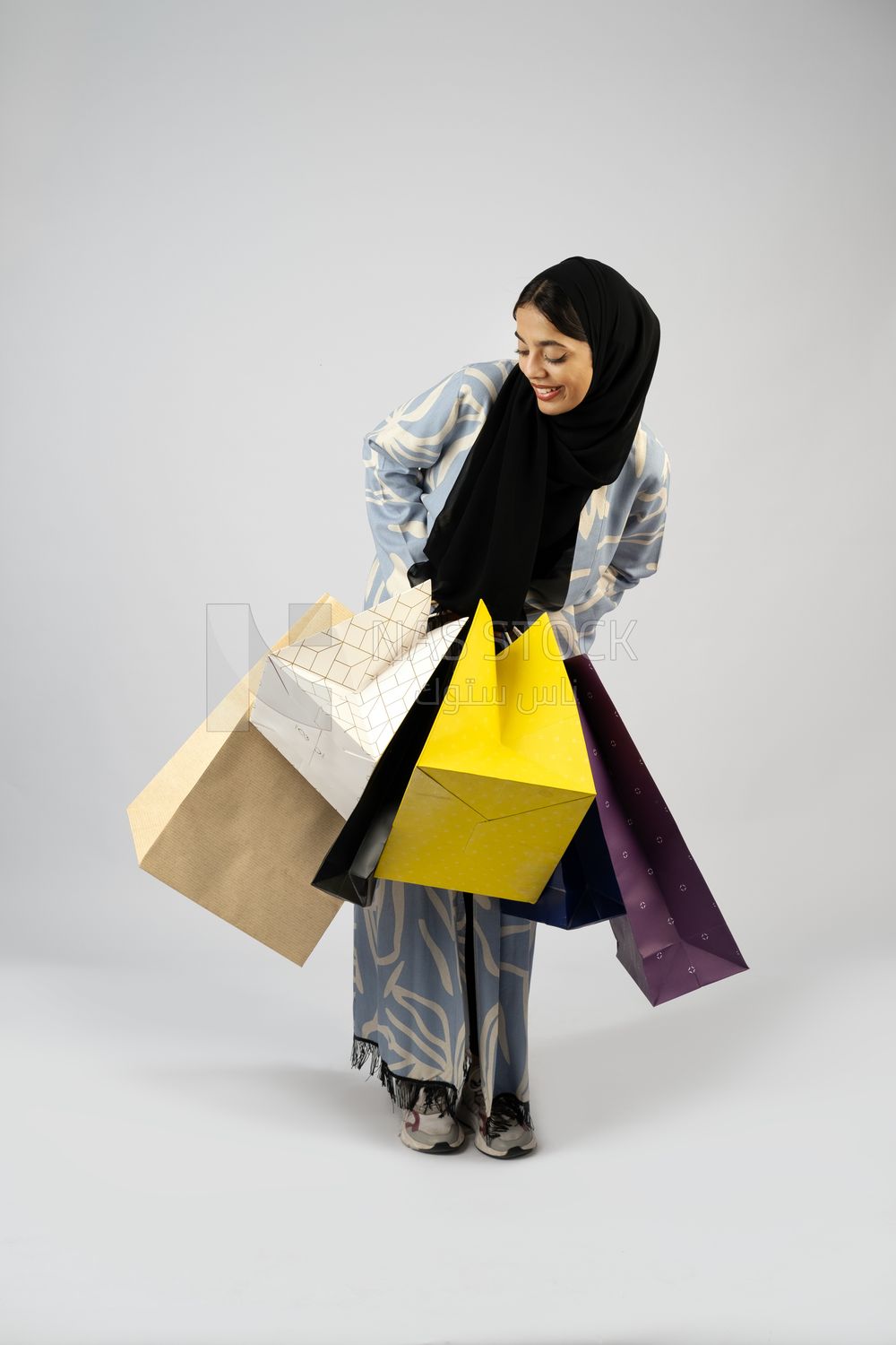 Gulf girl carrying colorful shopping bags