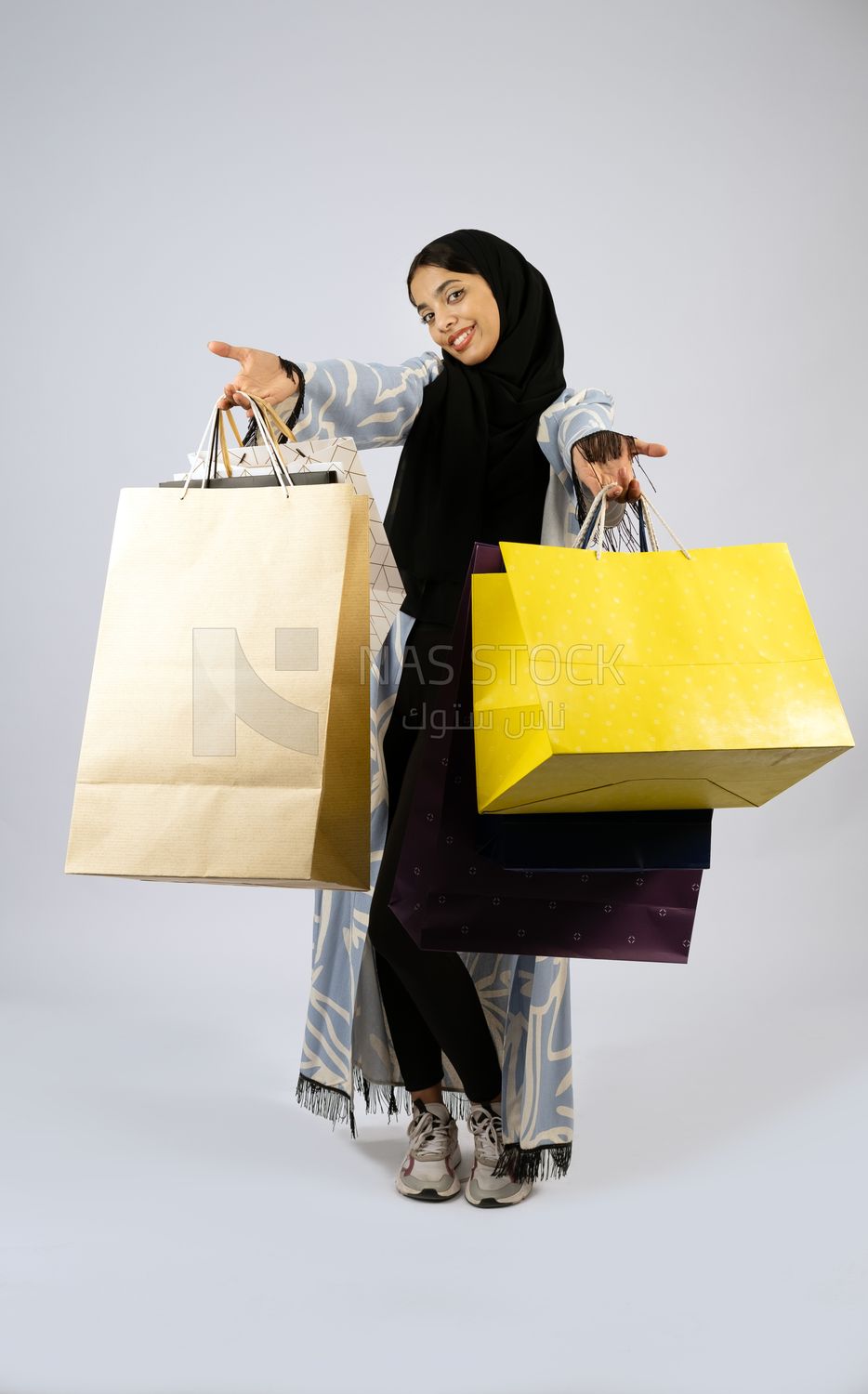 Gulf girl carrying colorful shopping bags