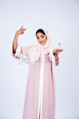 Gulf woman holding perfume bottle