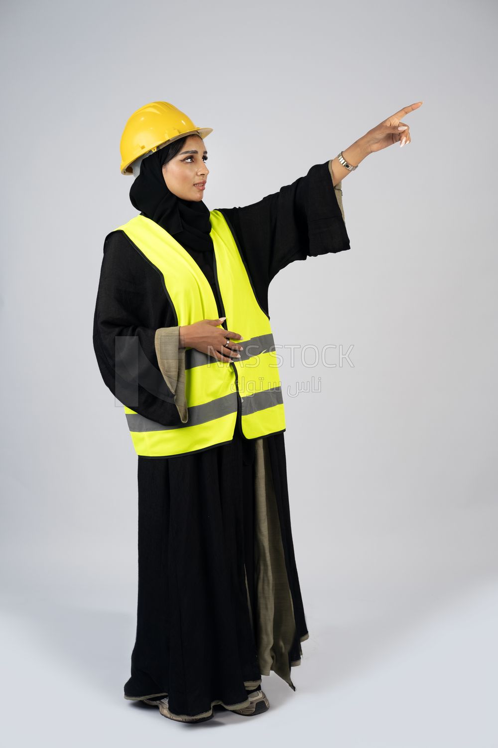 Veiled Gulf engineer wearing a safety suit and helmet