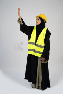 Veiled Gulf engineer wearing a safety suit and helmet