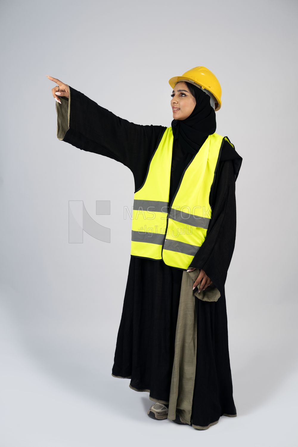 Veiled Gulf engineer wearing a safety suit and helmet