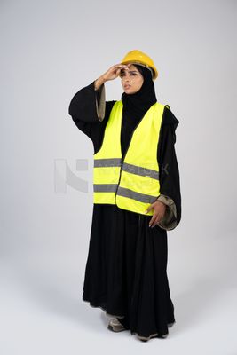 Veiled Gulf engineer wearing a safety suit and helmet