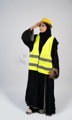 Veiled Gulf engineer wearing a safety suit and helmet
