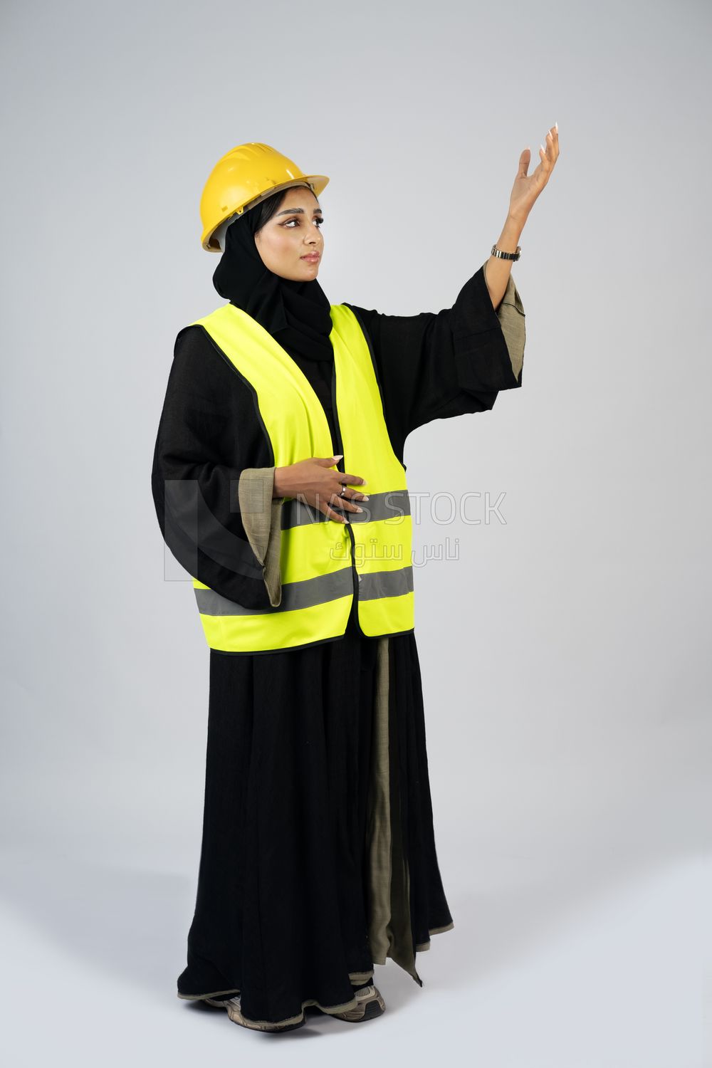 Veiled Gulf engineer wearing a safety suit and helmet