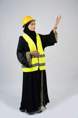 Veiled Gulf engineer wearing a safety suit and helmet