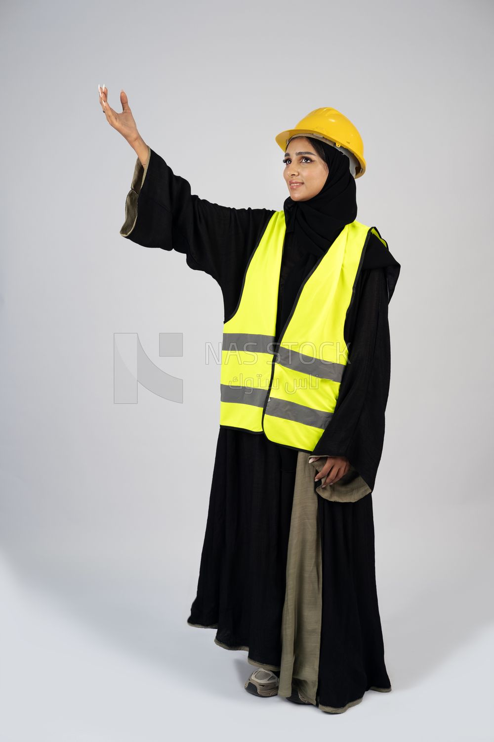 Veiled Gulf engineer wearing a safety suit and helmet