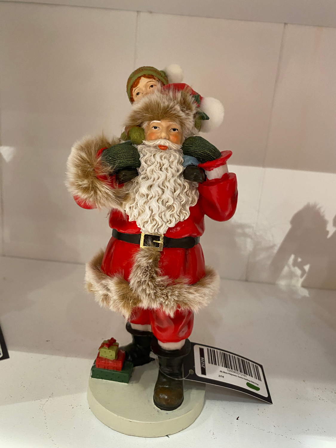 Père Noël debout portant un enfant sur les épaules