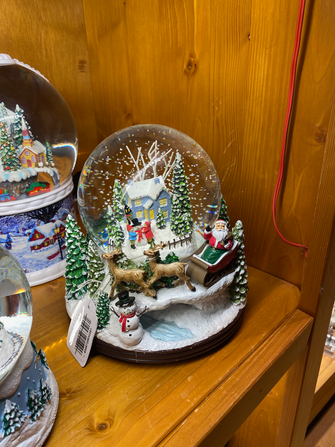 Boule à neige maison enneigée et traineau du Père Noël
