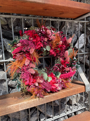 Herbstlicher Türkranz oder Tischdekoration: Trockenblumenkranz aus frisch getrockneten Blüten in warmen Brombeer Tönen als Weihnachtsdekortion .