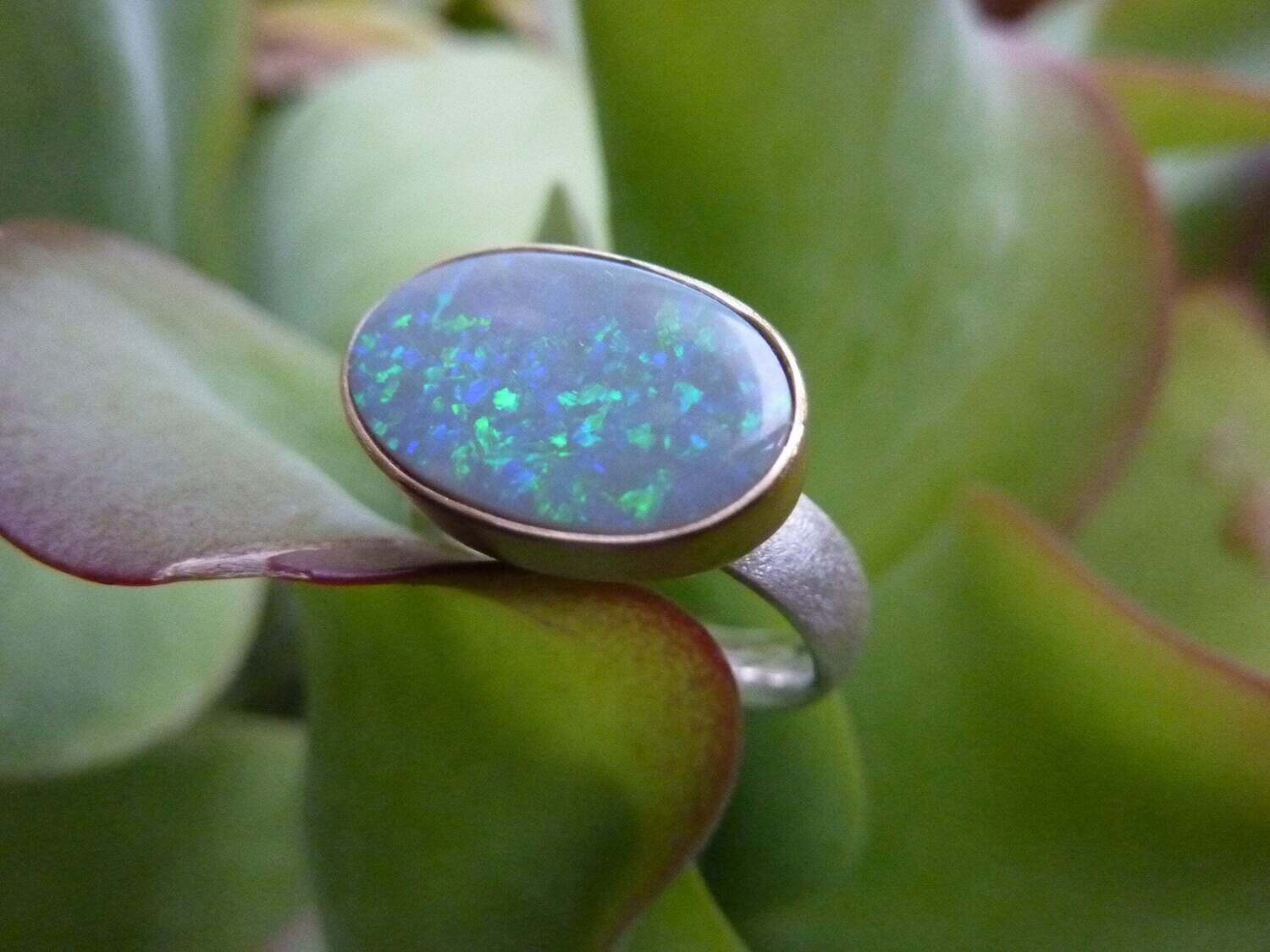 Ring, handgefertigt in Silber mit einem in Gold gefassten schwarzen Opal