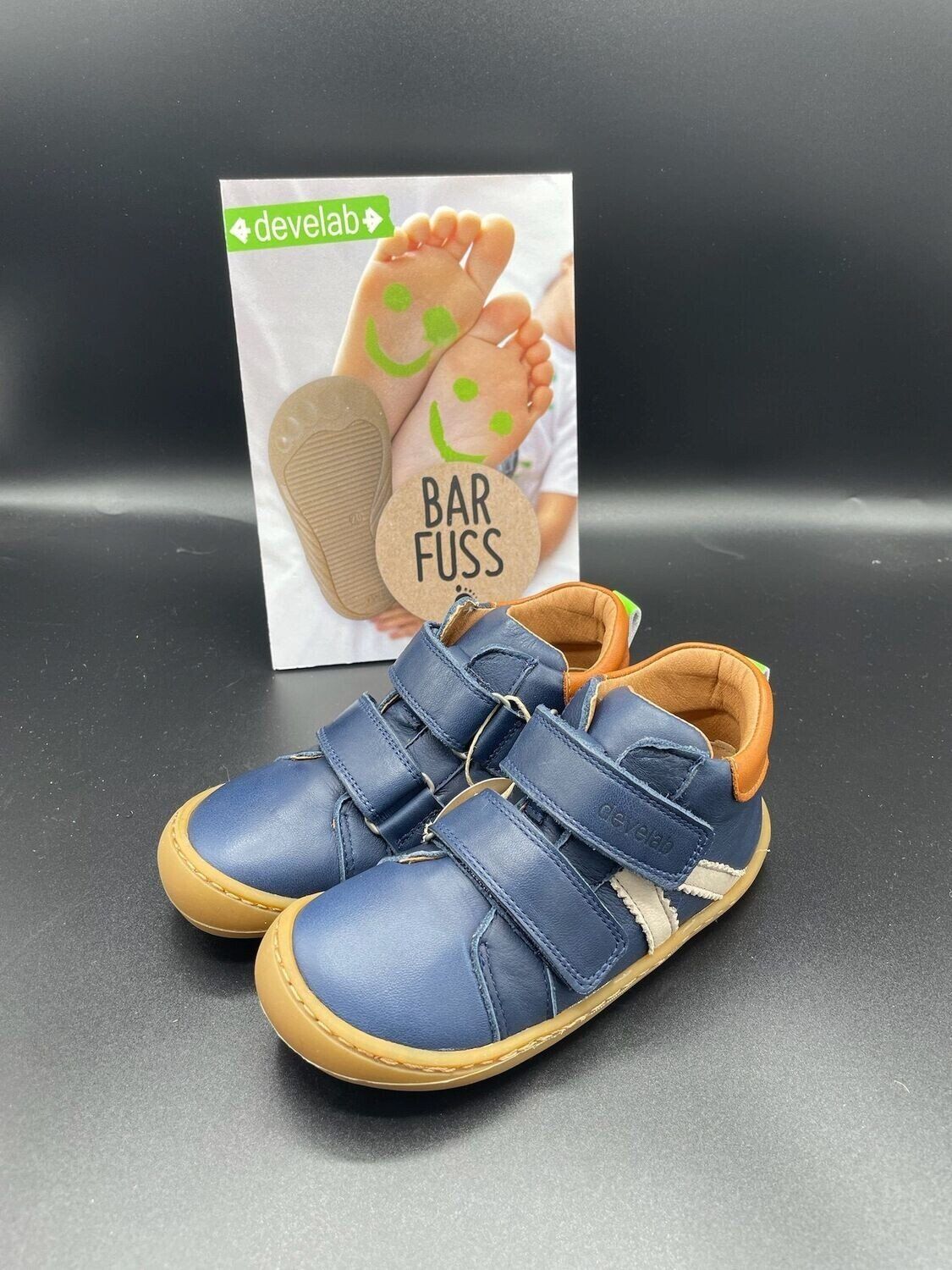 Seitenansicht des Develab Barfußschuhs in Navy mit zwei Klettverschlüssen und heller Gummisohle