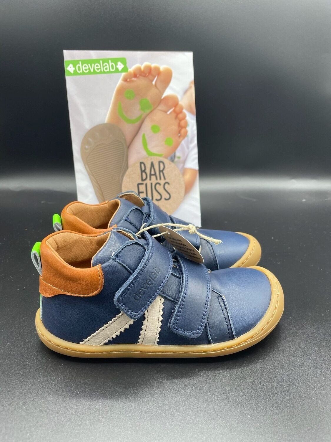 Seitenansicht des Develab Barfußschuhs in Navy mit zwei Klettverschlüssen und heller Gummisohle

