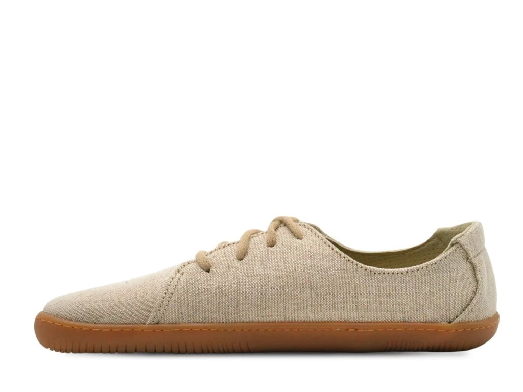 Seitenansicht des Aylla Nuna Barfußschuhs in Beige – schlichtes Baumwoll-Design mit flacher Naturso…
