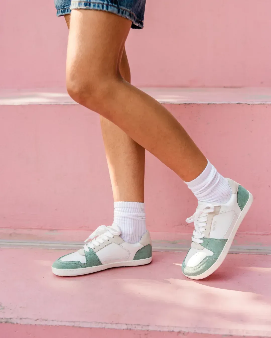 Barfußsneaker Re:Wind Jade am Fuß – Bewegungsszene mit pinker Wand