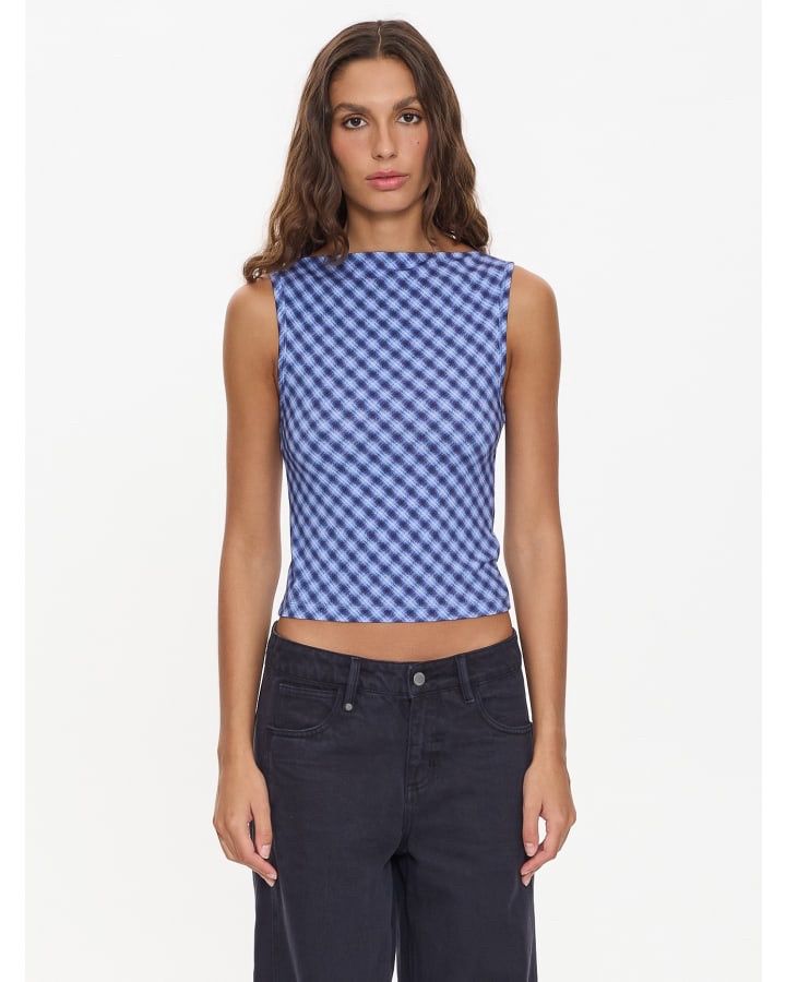 Model wearing a fitted, blue and white micro-check tank top featuring a modern boat neckline in a mid-shot view.