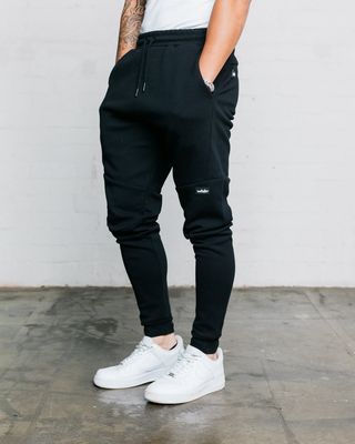man wearing black hoxton trackpants. showing the generous pockets 
