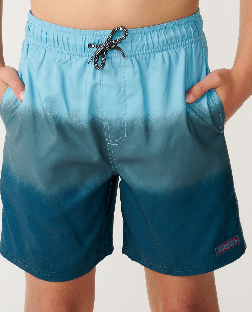 A male model wearing the Ripcurl Dip Volley Boys Shorts [8-16YEARS] detailing the Draw string and two function pockets.
