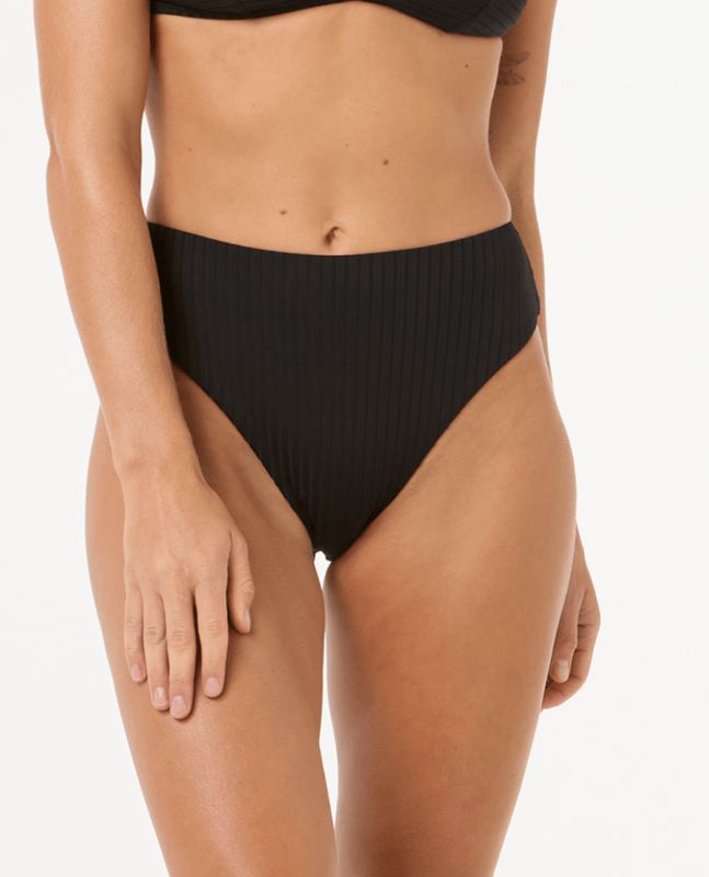 A close up of a female model wearing the RipCurl Premium Surf Retro High Pant in Black showing the texture and coverage.